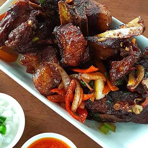Mister Wok Lamb Ribs — young Dopa lamb ribs prepared in three stages for fall-tender texture, sticky-sweet sauce with a quiet punch, Nairobi's most-ordered starter